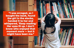 A young girl reaching for a book on the bookshelf